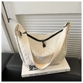 Close-up of beige quilted nylon crossbody bag featuring diamond stitching and wide strap - White