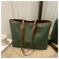 Macro detail of dark green woven tote bag with brown leather handles and textured surface - Green