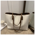 Close-up of white woven tote bag with brown leather straps and elegant interior decor - White