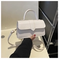 Detailed close-up of white crocodile pattern texture on a structured small square bag - White