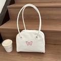 Borsa a spalla bianca in ecopelle con ricamo a farfalla rosa su una scala in legno - Bianco