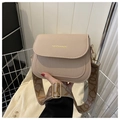 Detail der beigefarbene Satteltasche mit Krokostruktur und breitem Tragegurt mit Buchstabendruck - Khaki