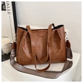 Detail of vintage brown leather tote bag with stylish black and white wave pattern strap - Brown