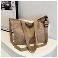 Detail of khaki corduroy tote bag with black hardware on minimalist white display stand - Khaki