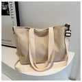 Close-up of beige corduroy tote bag texture with adjustable strap and sturdy handles - Off White
