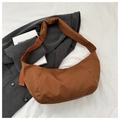 Detailed macro view of a brown nylon crescent moon bag on aesthetic fabric background - Brown