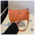 Detail of a bright orange nylon crescent shoulder bag with silver metal branding and zipper - Orange