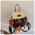 Close-up of vintage bucket backpack with contrast colors and cute plush charm detail - White & Coffee