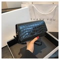 Détail du sac bandoulière noir motif crocodile avec boucle dorée sur boîte cadeau - Noir