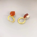 Detailansicht der silbernen Ohrringe mit leuchtend orangen Kristallen und Goldringen - Burgunderrot