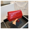 Détail d'un petit sac carré rouge à motif crocodile avec texture brillante et bandoulière - Rouge