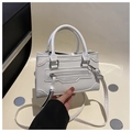 Detail showing the white patchwork crossbody bag with decorative zippers and top handle - White