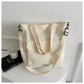 Close-up of beige corduroy tote bag showing textured fabric and black adjustable strap - White