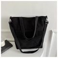 Close-up of black corduroy tote bag with adjustable shoulder strap and large front pocket - Black