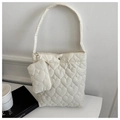 Detail view of heart-shaped quilted pattern and snap button on white puffer bucket bag - White