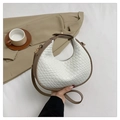 Dettaglio della borsa a luna intrecciata in ecopelle bianca con bordi marroni su un blazer - Bianco