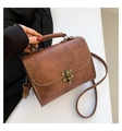 Close-up of vintage brown embossed leather texture and antique metal twist lock detail - Brown