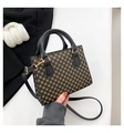 Dettaglio di borsa squadrata vintage con motivo geometrico giallo e finiture dorate - Nero