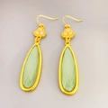 Pendientes vintage bañados en oro con piedra verde facetada y dijes de flores - Dorado