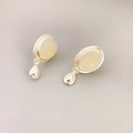 Detailsicht auf ovale Achat-Silberohrringe mit tropfenförmigen Metallanhängern - Silber + Weiß
