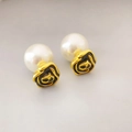 Close-up of vintage black enamel rose earrings with detachable white pearls and gold trim - Black