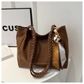 Detail of brown litchi pattern tote bag featuring woven handle and decorative silk scarf - Brown
