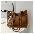 Detailed texture of brown pebble leather tote bag with woven handle and silk scarf detail - Brown