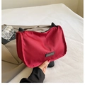 Macro detail of wine red nylon shoulder bag with black strap and silver zipper - Red