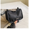 Dettaglio borsa a tracolla in nylon nero con tessuto resistente e logo sobrio - Nero