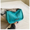 Dettaglio della borsa a spalla in nylon verde acqua con placca in metallo e tessuto liscio - Blu