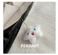 Close-up of a white plush star-shaped charm with a cute face on a black leather bag - White Star Plush Pendant