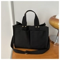 Detalle del bolso tote de lona negra con bolsillos frontales y remaches metálicos - Negro