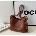 Dettaglio borsa a mezzaluna in pelle marrone vintage con cerniera dorata e tracolla - Marrone