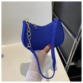 Close-up of blue felt underarm bag featuring V-shaped quilting and gold chain strap - Sapphire Blue