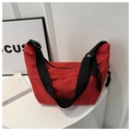 Close-up of red nylon tote bag featuring black woven strap and drawstring detail - Red