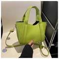 Detalle de un mini bolso tote verde lima en piel sintética con bandolera y asas de mano - Verde