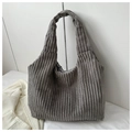 Macro shot of grey corduroy tote bag showing thick vertical texture and soft fabric - Gray