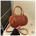 Detalle del bolso rojo óxido acolchado en V con logo dorado y correa de hombro ajustable - Marrón