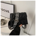 Detail of black quilted crossbody bag featuring a geometric patterned wide strap - Black