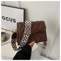 Detail of dark brown crossbody bag featuring geometric quilted texture and wide strap - Brown