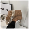 Detail view of brown quilted bag with unique geometric pattern and wide woven strap - Khaki