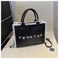 Dettaglio della borsa tote in pelle nera con bordo in pile bianco e logo TENGYUE - Nero
