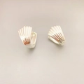 Elegant silver shell-shaped hoop earrings in polished brass with modern textured finish - Silver
