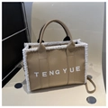 Dettaglio borsa tote in pelle cammello con bordo in pelliccia sintetica bianca e logo - Cachi