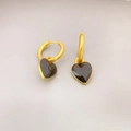 Primer plano de pendientes de aro dorados con colgantes de corazón en esmalte negro - Bordado Corazón Negro