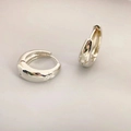 Polierte silberne Creolen mit Sternenmuster und Zirkonia auf minimalistischem grauem Grund - Weißgold Pavé