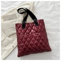 Quilted burgundy padded tote bag featuring black woven handles and a front pocket - Red