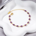 Detail of 18K gold-plated bracelet with purple glitter balls on white ceramic dish - Gold Purple