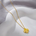 Detailed view of a gold clover pendant necklace on a decorative white tray with soft lighting - Smooth Four Leaf Clover Necklace (FX460) / Gold