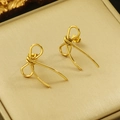 Makroaufnahme goldener Schleifenohrringe mit poliertem Design in einer Schmuckschachtel - Gold